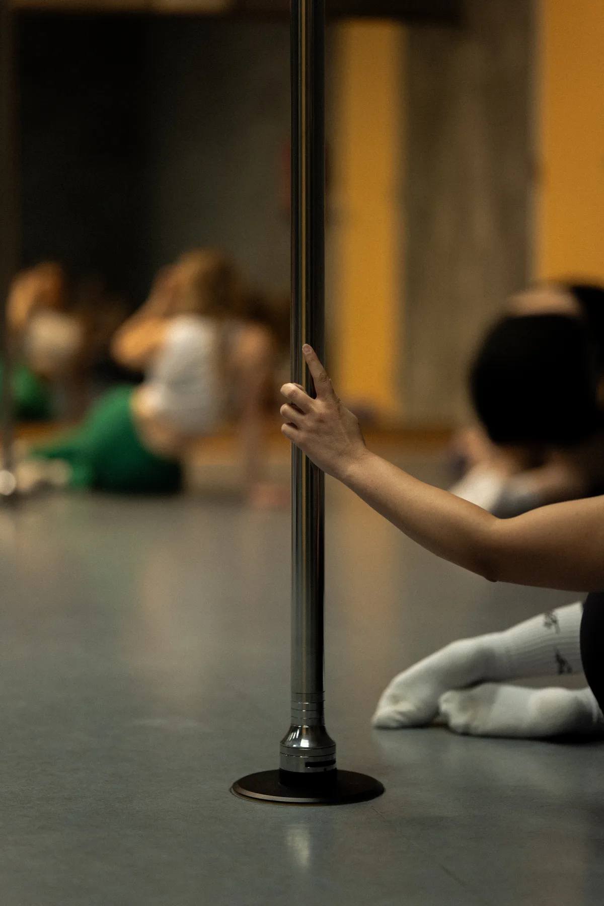 A beginner learning pole technique in class